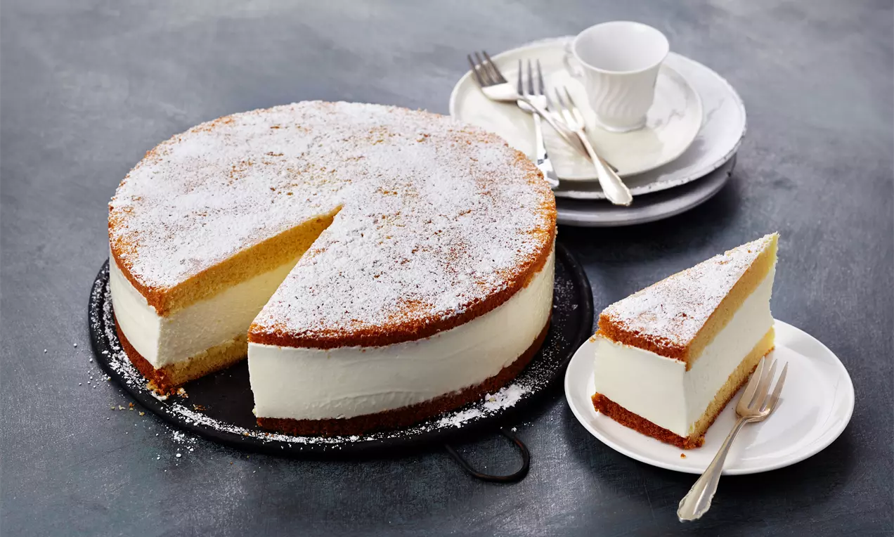 Torta iz skute in smetane s svetlim, kremastim nadevom.